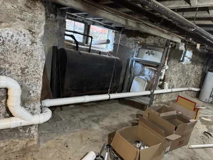 New PVC sewer line running along a basement wall