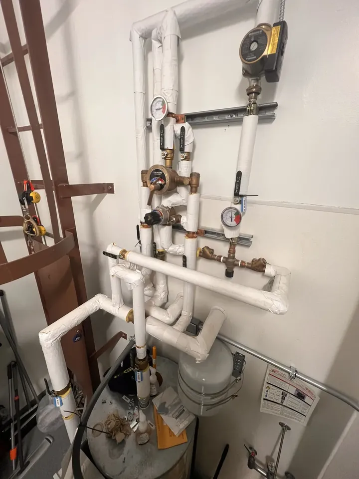 Insulated commercial hot-water station with a Leonard thermostatic mixing valve, Grundfos recirculation pump, and gauges