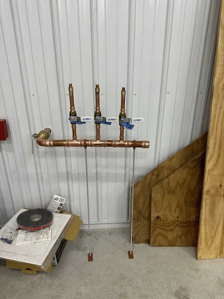 Copper distribution manifold with individual branch valves mounted on a wall