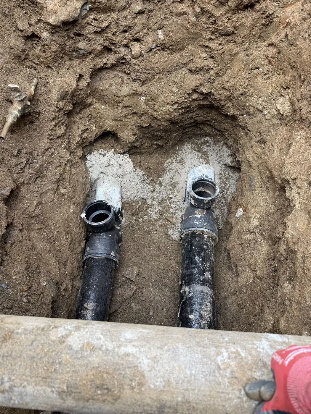 A new curb trap with two cleanouts set on the sewer lateral in an open excavation