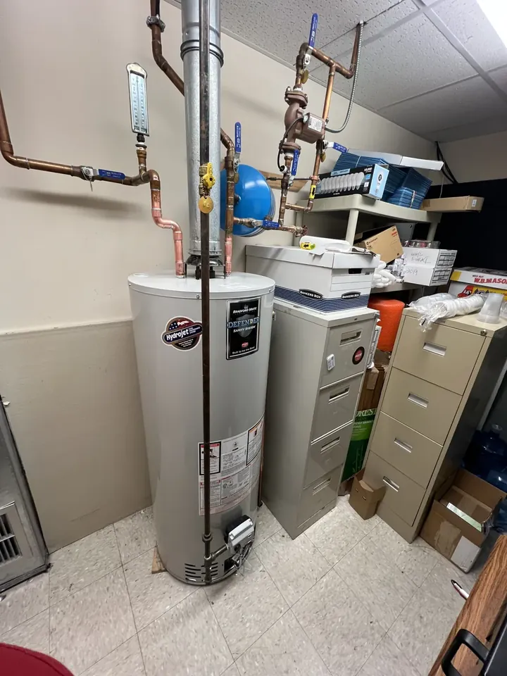 Two water heaters and an expansion tank in an office building mechanical room