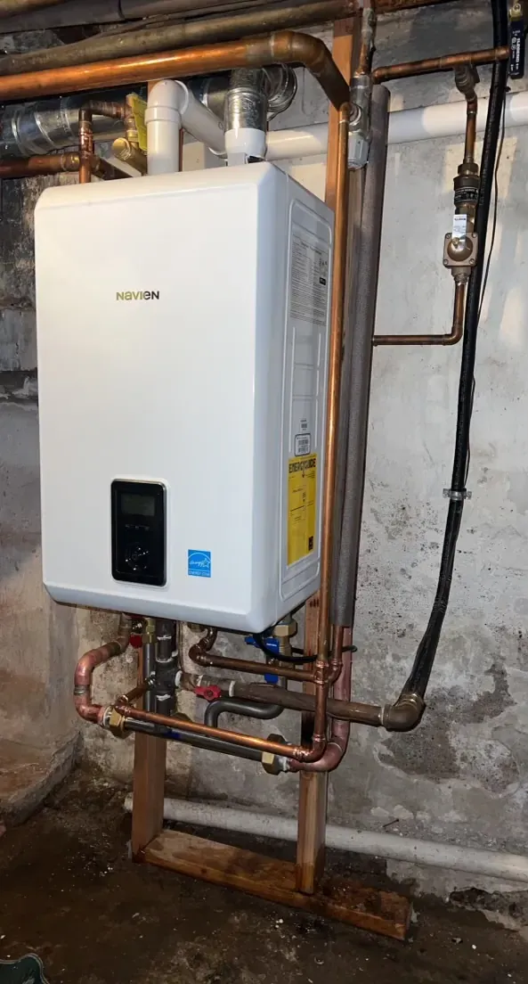 Wall-mounted tankless water heater with new copper supply lines and venting