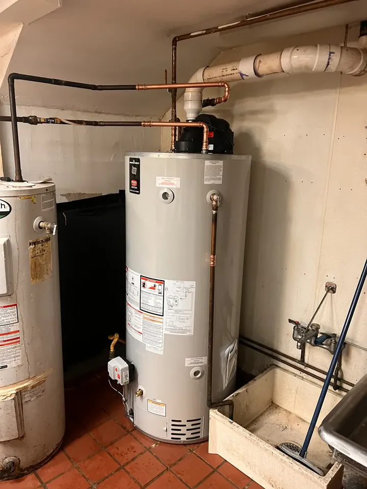 Replacement tank water heater on a tiled basement floor with copper connections